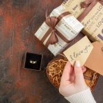 Cadeaux personnalisés et bague gravée posés autour de biscuits, évoquant l’élégance d’un présent unique et l’émotion d’un souvenir précieux pour une occasion spéciale