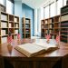 Bibliothèque contemporaine baignée de lumière naturelle, avec des rayonnages de livres non identifiés, un manuscrit juridique ouvert sur une table en bois et de petits drapeaux américains discrets.